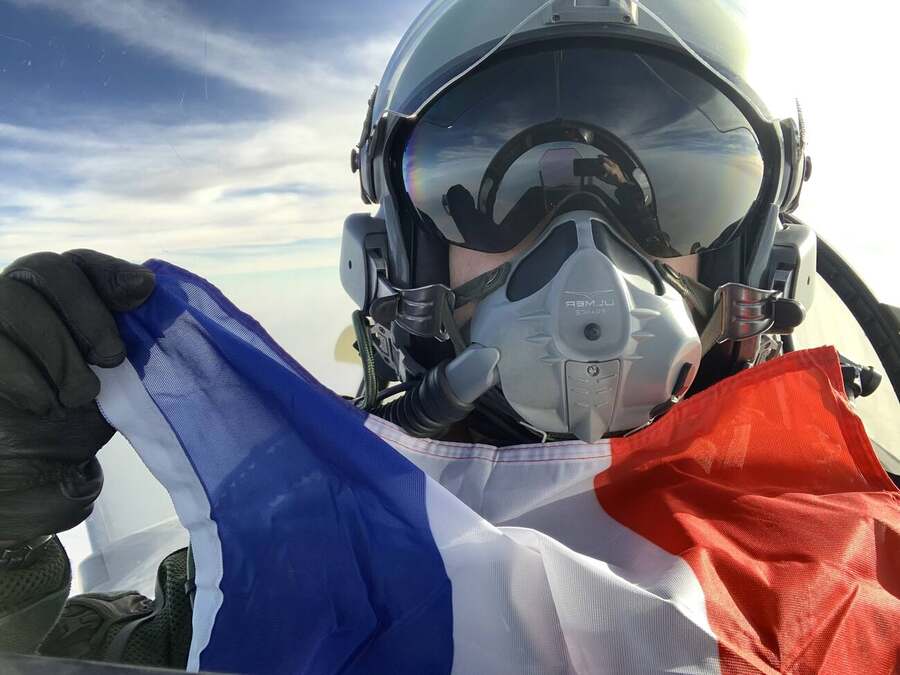 Pilote en vol, drapeau tricolore déployé dans le cockpit